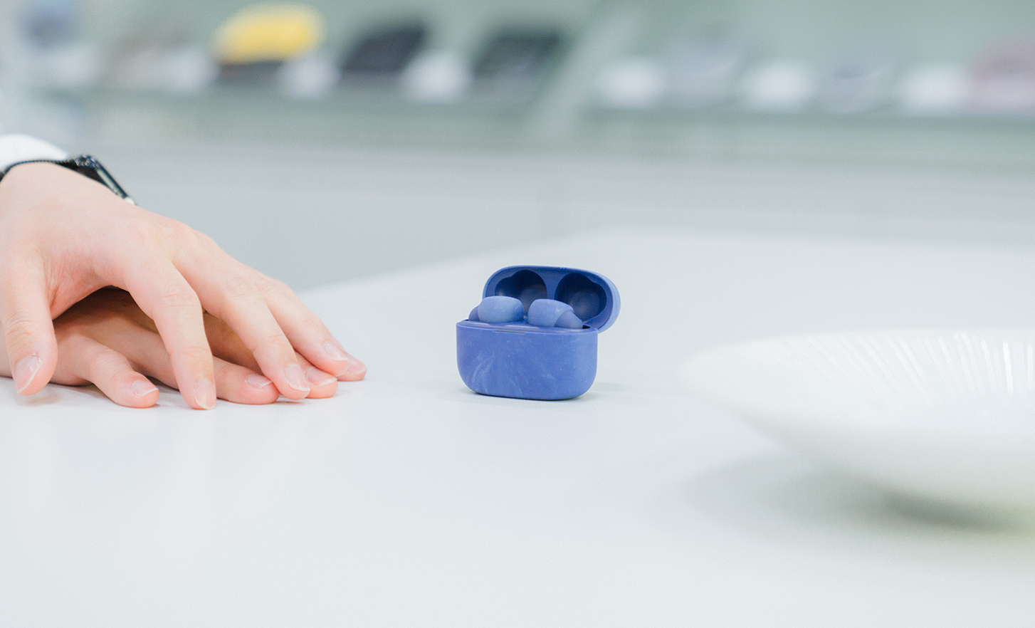 Des écouteurs dans un étui bleu sont posés sur la table