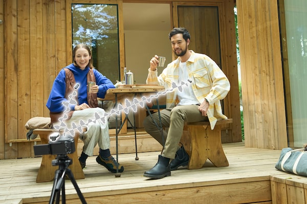 Image de deux hommes et deux femmes filmant avec un appareil photo et un microphone.