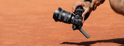 Image d’un homme accroupi tenant l’appareil pour filmer près du sol