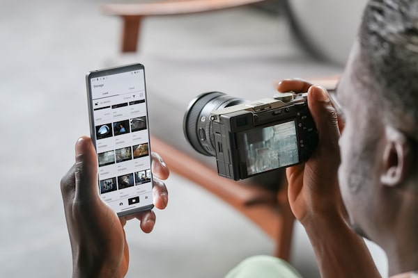 Image d’un homme transférant des photos à un téléphone intelligent depuis l’appareil photo