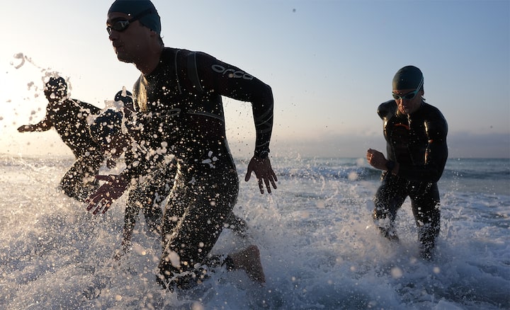 Image de quatre triathlètes sortant de l’eau