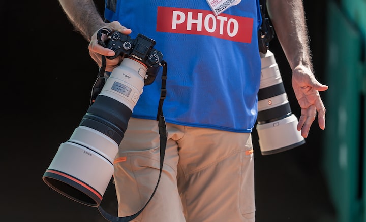 Image d’utilisation montrant un photographe masculin transportant deux appareils photo avec des téléobjectifs