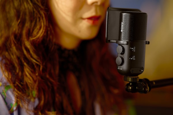 Image d’utilisation montrant une femme chantant avec la bouche proche du microphone avec la protection antiplosive installée