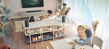 A family seated in different areas of a living room watching TV, surrounded by a blue dome effect representing 360 Spatial Sound