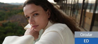 Portrait d’une femme qui regarde doucement cet objectif. Elle a été filmée de près. Toutefois, la photo laisse une impression de profondeur