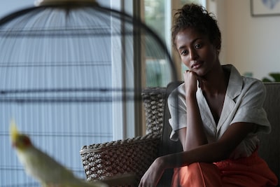 Portrait d’une femme avec une cage à oiseaux au premier plan