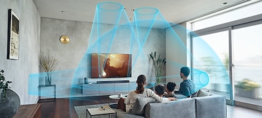 Family on a sofa watching TV with the HT-A7000 soundbar on a marble cabinet