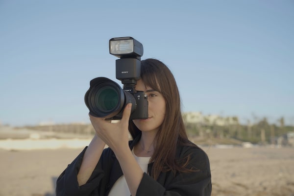 Image d’un photographe tenant l’appareil avec un flash externe monté