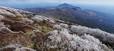 Un vaste paysage montrant une série de montagnes. La montagne à l’avant-plan est couverte de neige et mise au point