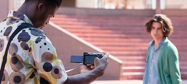 Image d’un homme tenant l’appareil photo pour filmer un autre homme à l’extérieur